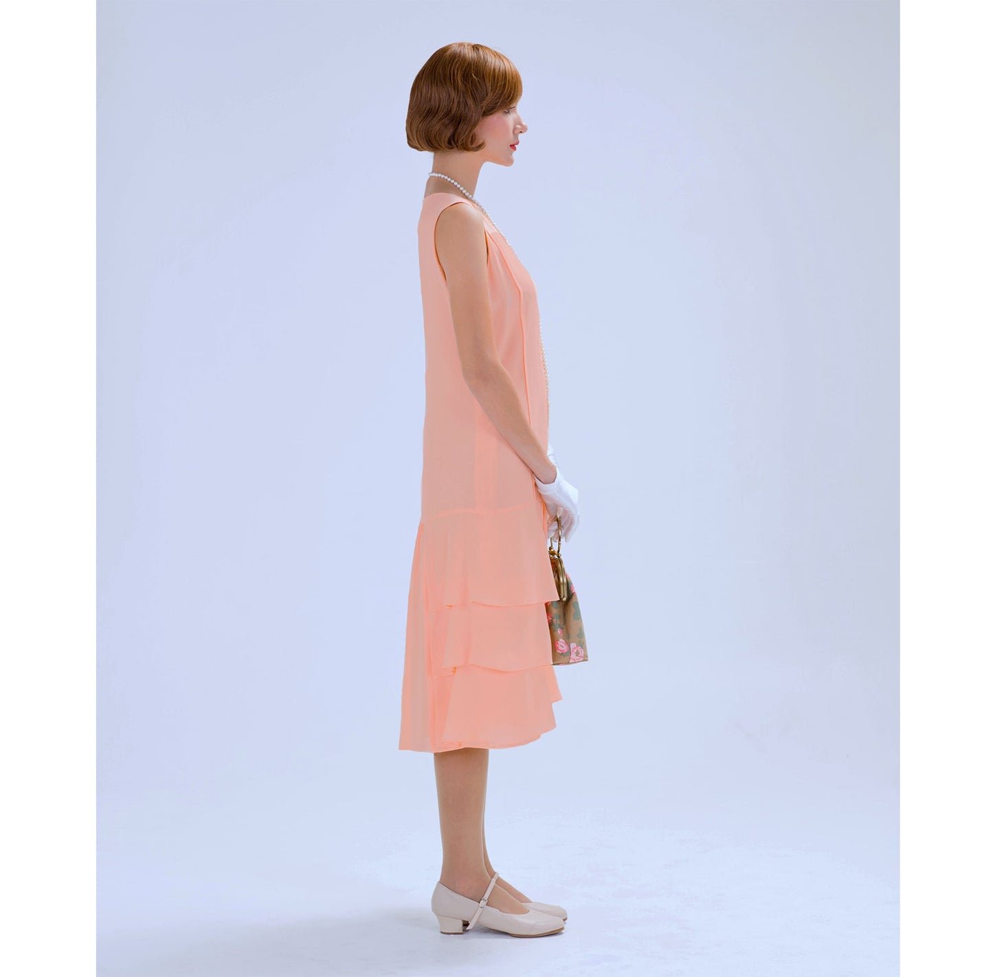 A peach chiffon 1920s dress with a tiered skirt that can be worn as a Great Gatsby day dress or a Jazz Age lawn party dress.