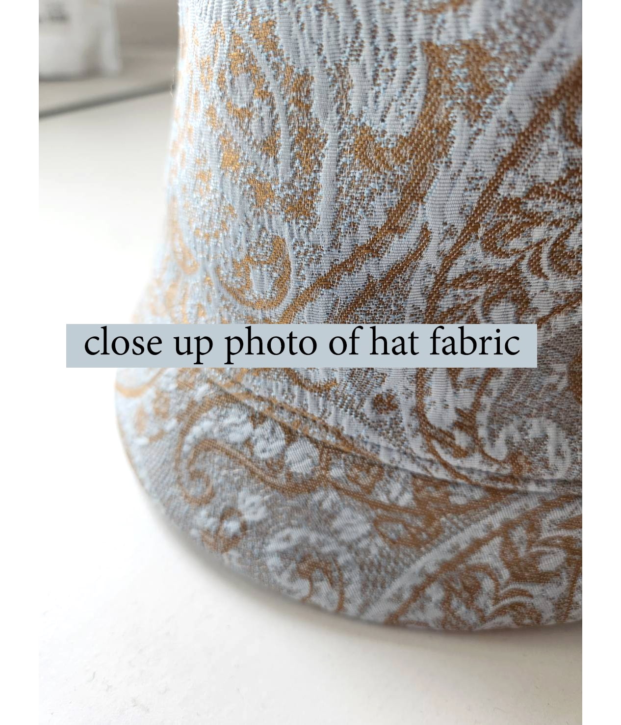 Light blue and brown cloche hat with multicolored art deco print ribbon