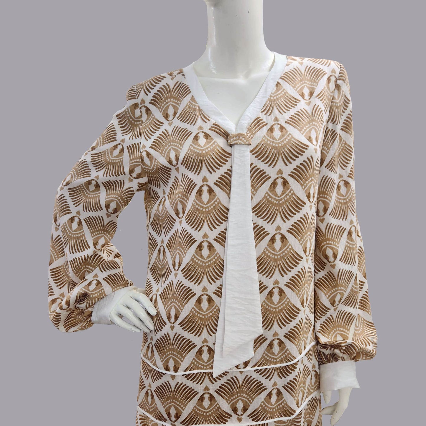 Mannequin wearing a patterned brown and white dress - an art deco dress