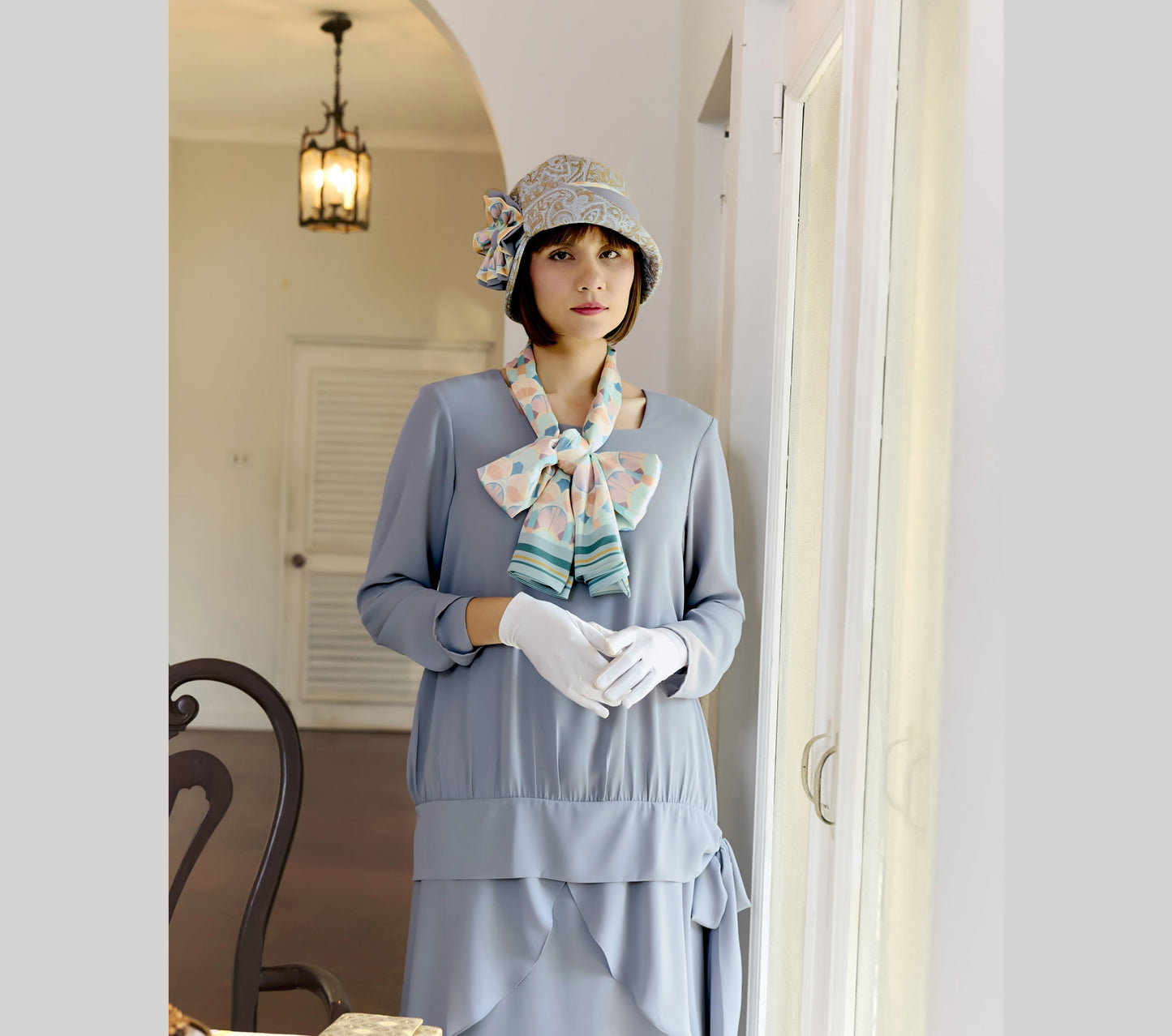 Light blue and brown cloche hat with multicolored art deco print ribbon