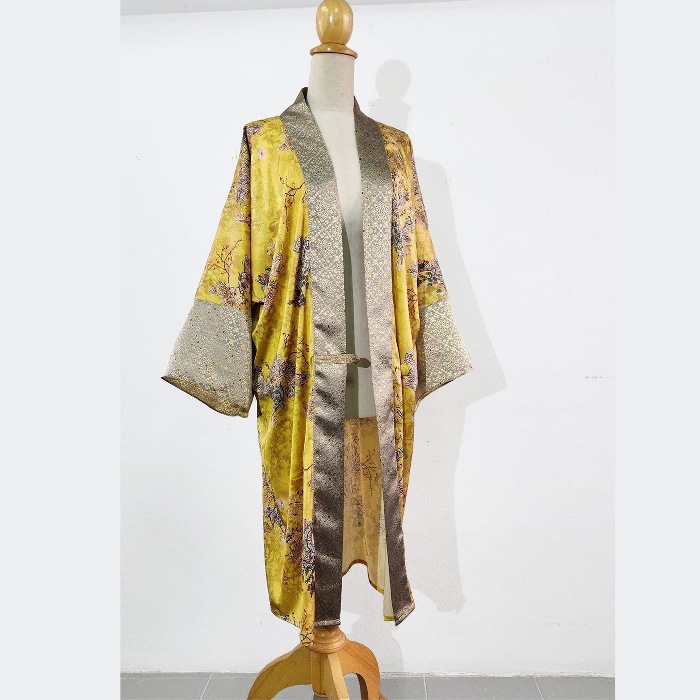 A Japanese kimono robe inspired by the 1920s loungewear fashion. This 1920s coat is made of printed yellow satin.