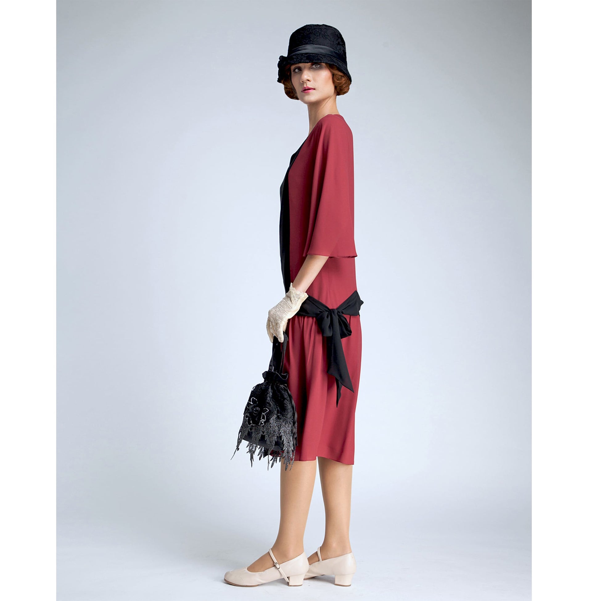 Roaring twenties dress, or Gatsby dress, with elbow length sleeves inspired by art deco fashion in maroon red with black contrasting details. 