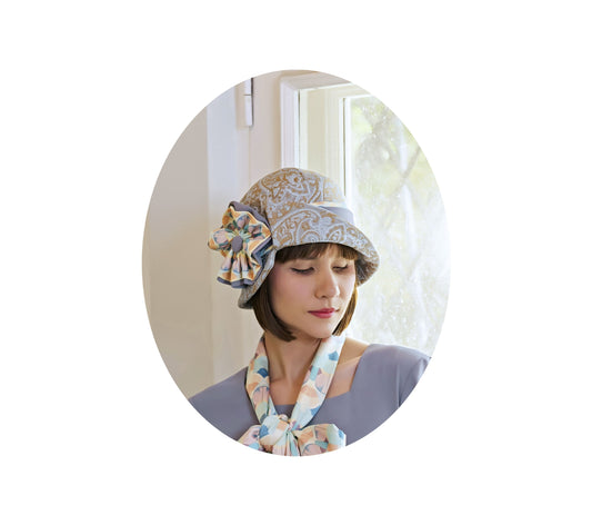 Light blue and brown cloche hat with multicolored art deco print ribbon - a 1920s hat