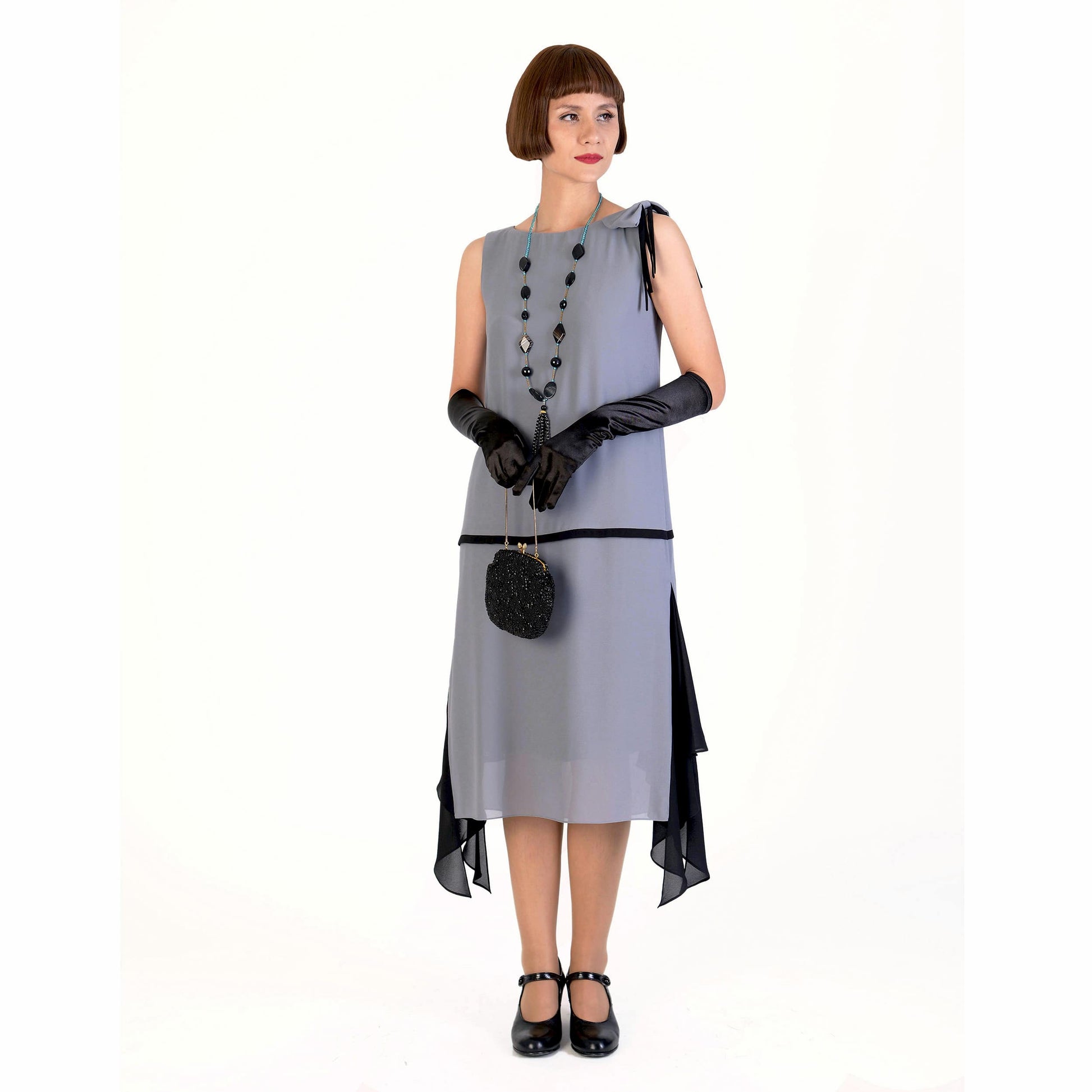 Grey party dress in 1920s style with black details and shoulder bow