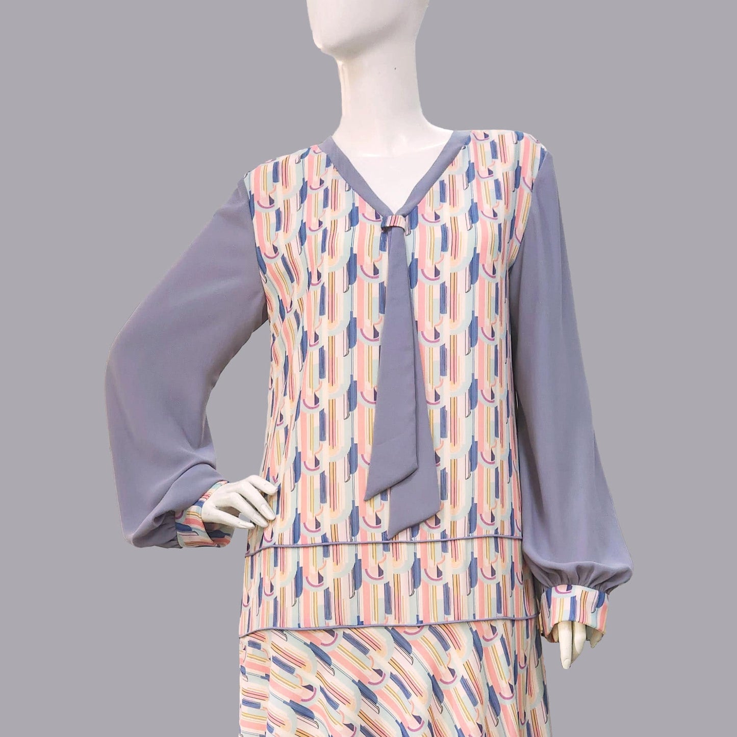 1920s fashion dress with a cheerful Art Deco pattern in light pastel shades