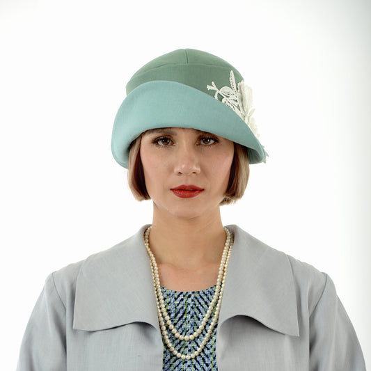 A 1920s-inspired linen cloche hat in muted green and pastel blue that matches some of our Great Gatsby coats.