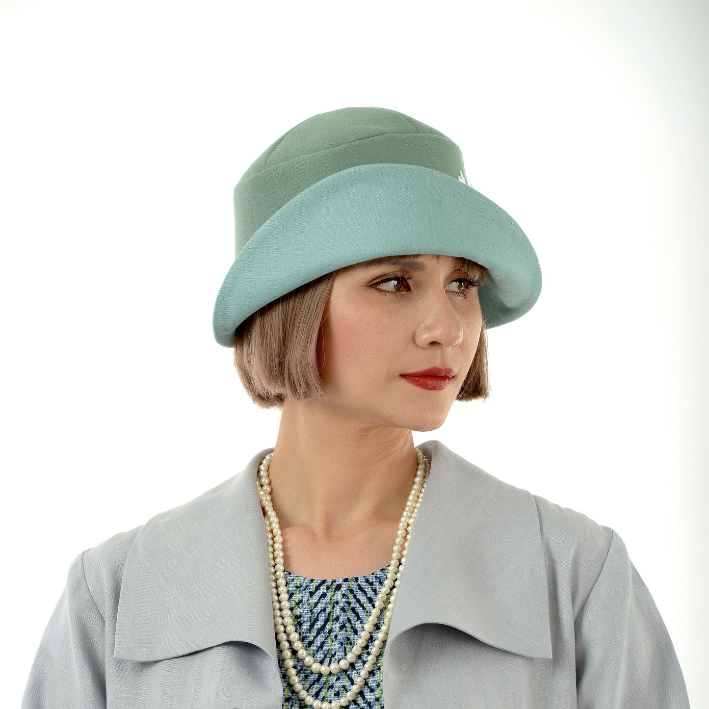 1920s-inspired linen cloche hat in muted green and pastel blue